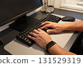 A man touching a computer keyboard, working from home as a side job 131529319