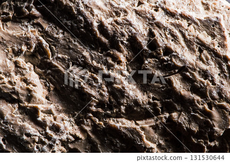 The surface of the stone has a complex texture. The details of the texture are clearly visible in macro photography. The stone looks natural and untouched. Marble, silicon, limestone, sandstone. 131530644
