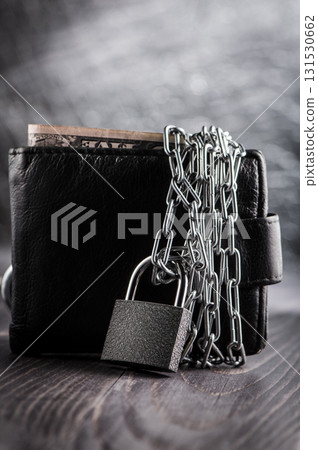 A wallet closed with a chain represents limited access to money A wallet closed with a chain represents limited access to money 131530662