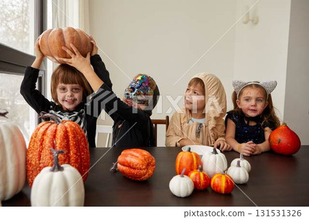Children joyfully celebrating Halloween with vibrant pumpkins and their fun costumes, together 131531326