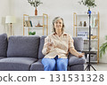 Senior elderly woman sitting on couch, receiving intravenous IV drip infusion and vitamin therapy. 131531328