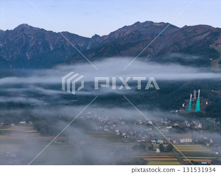 Early morning views of Mount Goryu and Mount Karamatsu, and the cityscape shrouded in a sea of clouds. Hakuba Village, Nagano Prefecture (aerial shot by drone) Early morning views of Mount Goryu and Mount Karamatsu, and the cityscape shrouded in a sea of clouds. Hakuba Village, Nagano Prefecture (aerial shot by drone) 131531934