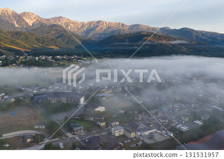 清晨，透過雲海望去，白馬村的街景和白馬三山的山脈盡收眼底。長野縣白馬村（無人機空拍） 131531957