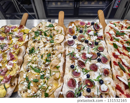 Delicious variety of gourmet pizzas served in a restaurant during a lively evening 131532165