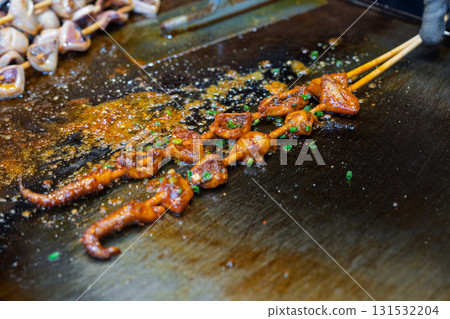 Close-up of grilled squid skewers on iron plate Close-up of grilled squid skewers on iron plate 131532204