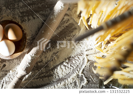 Homemade noodles hanging on wooden dryer rack over kitchen table background high angle top view 131532225
