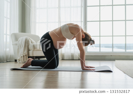 Pregnancy yoga fitness workout training. Pregnant woman practicing yoga at home. Pregnant girl doing sports exercise on yoga mat indoor. Woman with big belly have fitness training practicing asana Pregnancy yoga fitness workout training. Pregnant woman practicing yoga at home. Pregnant girl doing sports exercise on yoga mat indoor. Woman with big belly have fitness training practicing asana 131532817