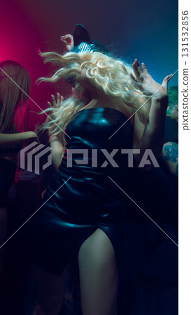 Woman in black cat mask and leather dress dancing at party 131532856