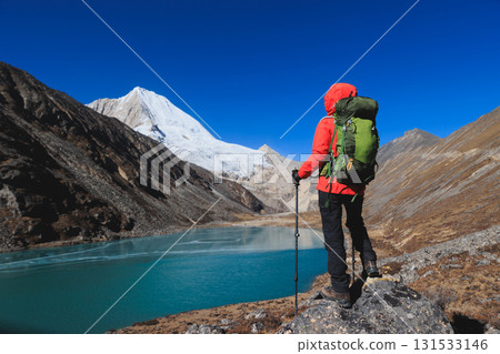 Backpacking woman hiking on high altitude mountain top 131533146