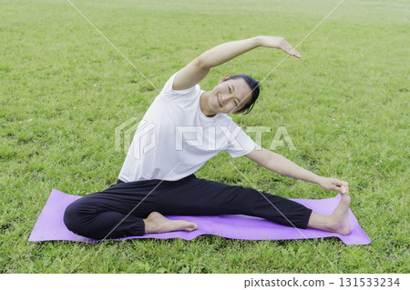 年輕人在公園的草地上做瑜伽 131533234