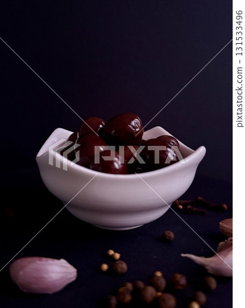 A bowl of black olives, still life with olives, garlic, and spices. A bowl of black olives, still life with olives, garlic, and spices. 131533496