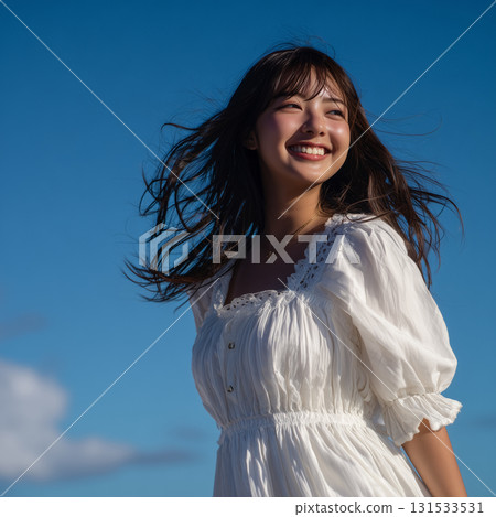 A refreshing portrait of a woman with a bright smile surrounded by blue skies and wind 131533531