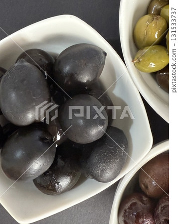 Closeup of green and black olives. Bowls of assorted olives still life. 131533737