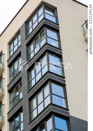 A tall and impressive building featuring numerous windows and balconies A tall and impressive building featuring numerous windows and balconies 131534134