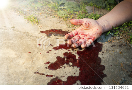 A man's hand in blood lies on the ground A man's hand in blood lies on the ground 131534631