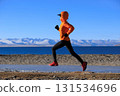 Woman runner training at winter lakeside 131534696