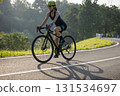Woman cyclist riding bike in summer park 131534697