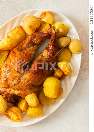 A beautifully presented dish features a whole baked rabbit surrounded by tender, golden-roasted potatoes. This comforting meal is perfect for family gatherings or special occasions. A beautifully presented dish features a whole baked rabbit surrounded by tender, golden-roasted potatoes. This comforting meal is perfect for family gatherings or special occasions. 131535864