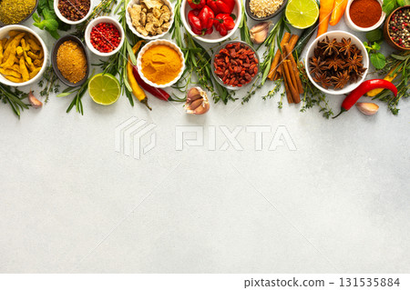 A vibrant assortment of spices and herbs on a gray background, offering a flavorful addition to any recipe, top view and copy space 131535884