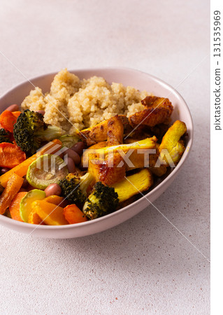 A well-balanced breakfast spread showcasing quinoa, baked sweet potato with carrots, zucchini, broccoli, beans, and baked chicken breast seasoned with turmeric 131535969