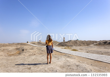 girl walk through the ruined area that destroyed by war in Uzbekistan, Bukhara during drought season 131535993