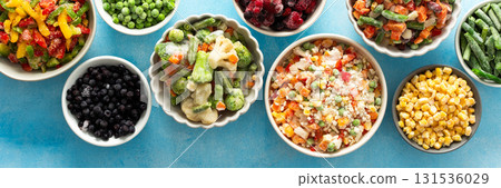A top view of colorful, frozen vegetables on plates, highlighting the process of preserving summer best produce for nutritious winter meals, banner,, vegetables in plates on a blue background A top view of colorful, frozen vegetables on plates, highlighting the process of preserving summer best produce for nutritious winter meals, banner,, vegetables in plates on a blue background 131536029