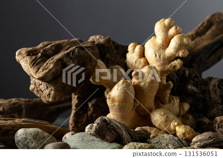 Ginger root with old snags and stones on a black background. Ginger root with old snags and stones on a black background. 131536051
