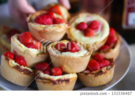 Fresh strawberry-topped cupcakes on rustic table. Fresh strawberry-topped cupcakes on rustic table. 131536487