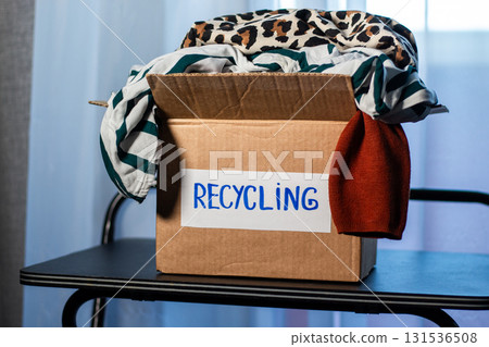 Box of used clothing marked for recycling. Eco friendly lifestyle. Closet management. 131536508