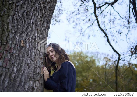 Two women in the long black dresses perform a historical reenactment of the Edwardian era on a hill near a majestic oak tree for Halloween. Two women in the long black dresses perform a historical reenactment of the Edwardian era on a hill near a majestic oak tree for Halloween. 131536898