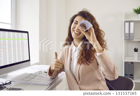 Smiling businesswoman looking through rolled up sheet of paper Smiling businesswoman looking through rolled up sheet of paper 131537165