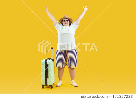 Fat woman in sunglasses with suitcase raising hands up on studio yellow background. Fat woman in sunglasses with suitcase raising hands up on studio yellow background. 131537228