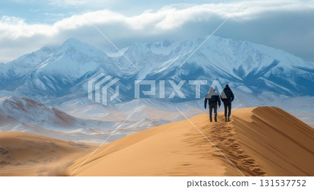 Couple walking on sand dunes with snow mountain. 131537752