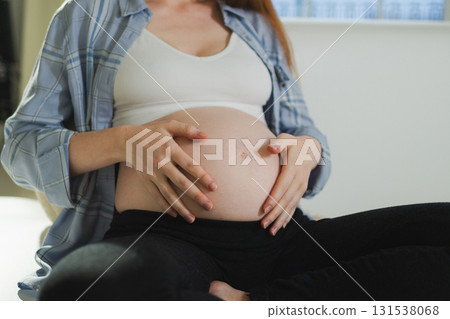 Pregnancy motherhood people expectation future. Pregnant woman hands touching big belly. Girl hugging her tummy enjoying pregnancy at home. Maternity tenderness parenthood new life concept 131538068