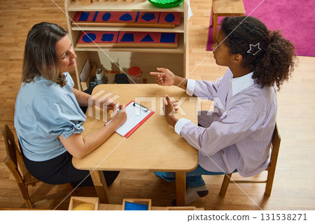 Focused teenager explaining thoughts to attentive female psychologist 131538271