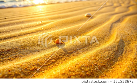 Close-up view of smooth golden sand dunes with gentle ripples and small scattered rocks under bright sunlight in a vast desert landscape du daytime 131538672
