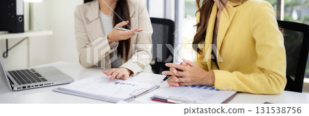 Asian adult women business professionals discuss financial analysis corporate strategy modern office environment promote teamwork Asian adult women business professionals discuss financial analysis corporate strategy modern office environment promote teamwork 131538756