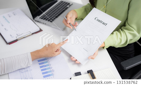 Adult Asian business professionals review contract terms collaborate office environment negotiation strategy discuss important business agreement deal Adult Asian business professionals review contract terms collaborate office environment negotiation strategy discuss important business agreement deal 131538762