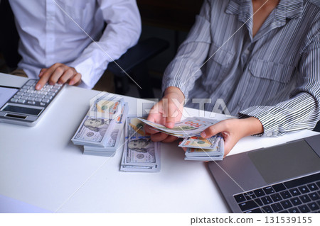 Two businesspeople, banker, account working together in office desk, calculating, counting money, analyze data 131539155