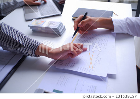 Two businesspeople, banker, account working together in office desk, calculating, counting money, analyze data Two businesspeople, banker, account working together in office desk, calculating, counting money, analyze data 131539157