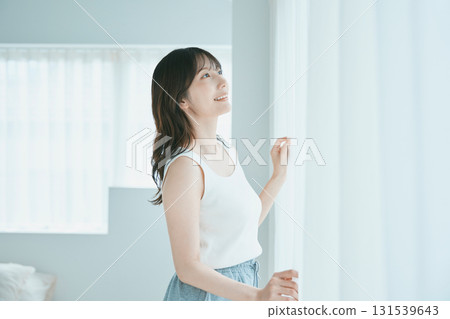Beauty image: A woman opening the curtains 131539643