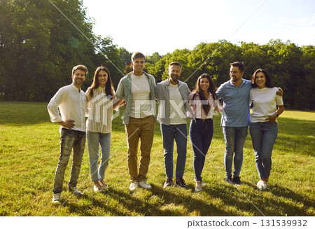 Group of happy young friends huddling and having fun in a green park in the summer Group of happy young friends huddling and having fun in a green park in the summer 131539932