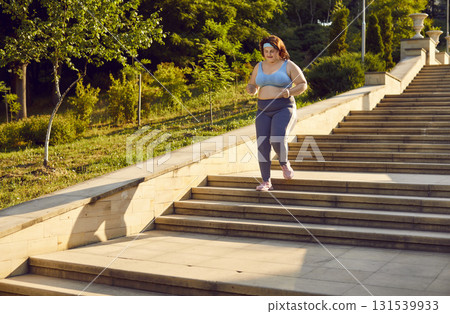Plus Size Woman Jogging Up Stairs In City Park Plus Size Woman Jogging Up Stairs In City Park 131539933