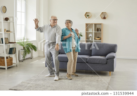 Happy senior family couple wife and husband dancing in the living room at home. 131539944