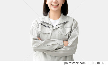 A young woman wearing work clothes and folding her arms 131540169