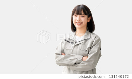 A young woman wearing work clothes and folding her arms A young woman wearing work clothes and folding her arms 131540172