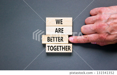 We are better together symbol. Concept words phrase We are better together on beautiful wooden blocks. Beautiful grey background. Businessman hand. Business We are better together concept. Copy space. 131541352