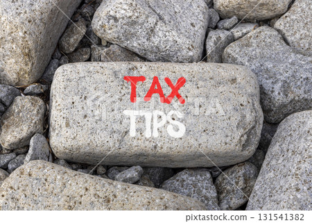 Tax tips symbol. Concept word Tax tips on beautiful grey stone on stone beach. Beautiful grey stone beach background. Business tax tips concept. Copy space. Tax tips symbol. Concept word Tax tips on beautiful grey stone on stone beach. Beautiful grey stone beach background. Business tax tips concept. Copy space. 131541382