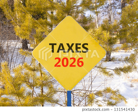 Taxes 2026 new year symbol. Concept words Taxes 2026 on beautiful yellow road sign. Beautiful winter forest background. Business and taxes 2026 new year concept. Copy space. Taxes 2026 new year symbol. Concept words Taxes 2026 on beautiful yellow road sign. Beautiful winter forest background. Business and taxes 2026 new year concept. Copy space. 131541430