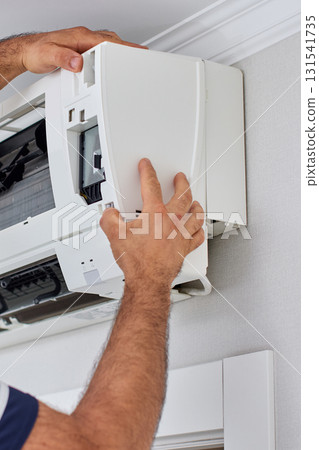 male hand of worker from the cleaning service cleans or repairs the air conditioner , close-up 131541735
